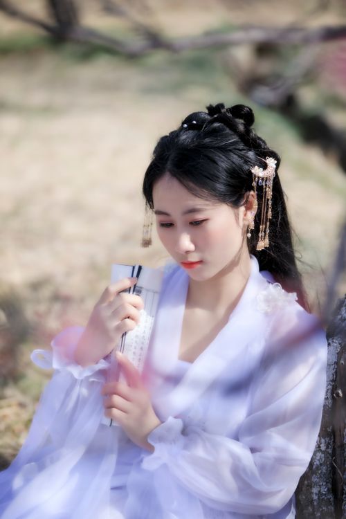 Free Beautiful portrait of a woman outdoors in traditional attire holding a fan, evoking grace and elegance. Stock Photo