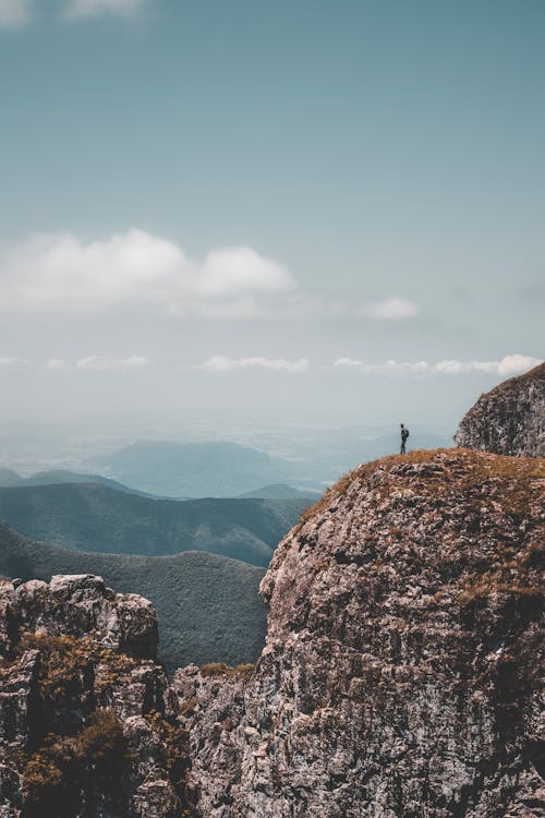 Free Person Standing On Rocky Mountain Cliff Stock Photo