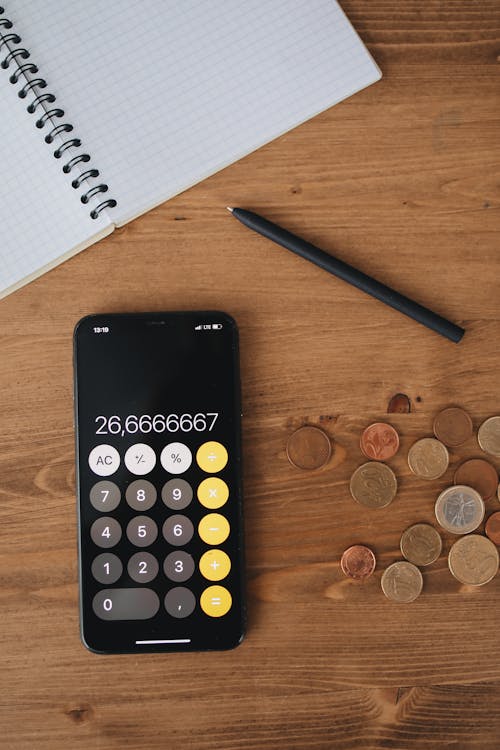 Free Notebook and Pen Beside A Calculator and Coins Stock Photo