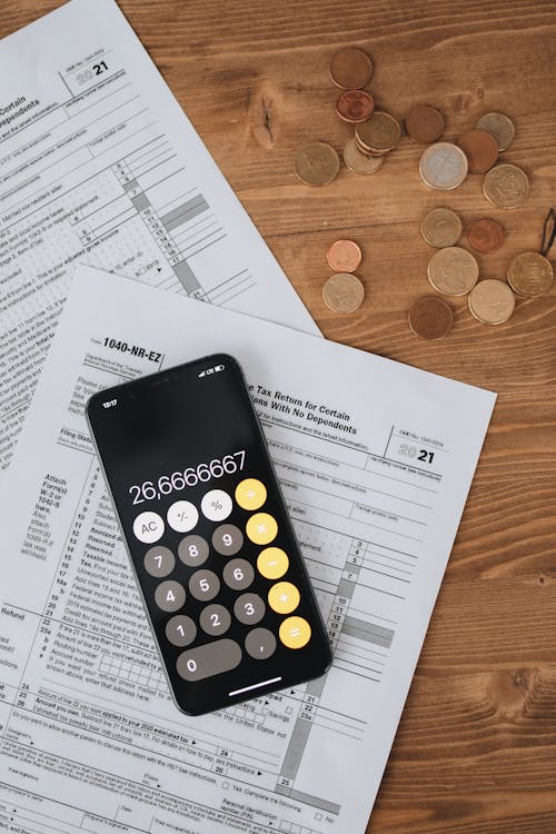 Tax Forms With Calculator With Coins On Wooden Surface