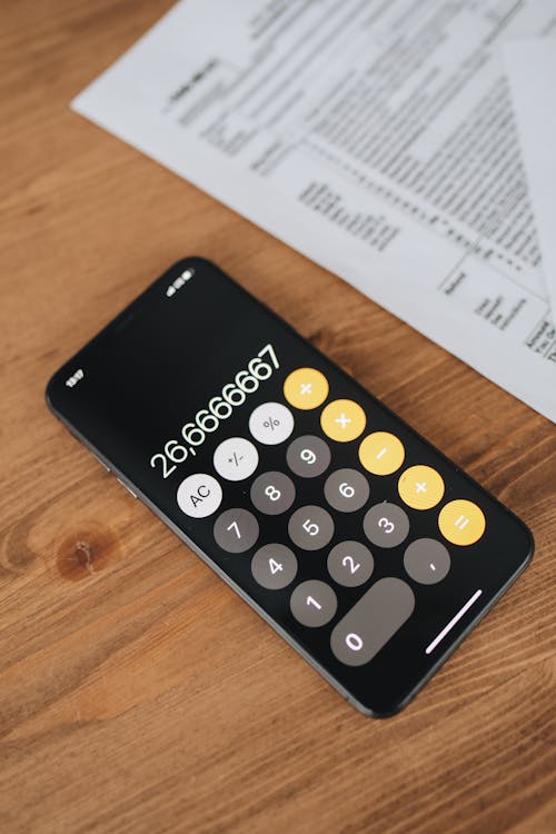 Free Black Calculator With Blur Image Of Tax Forms On Wooden Surface Stock Photo
