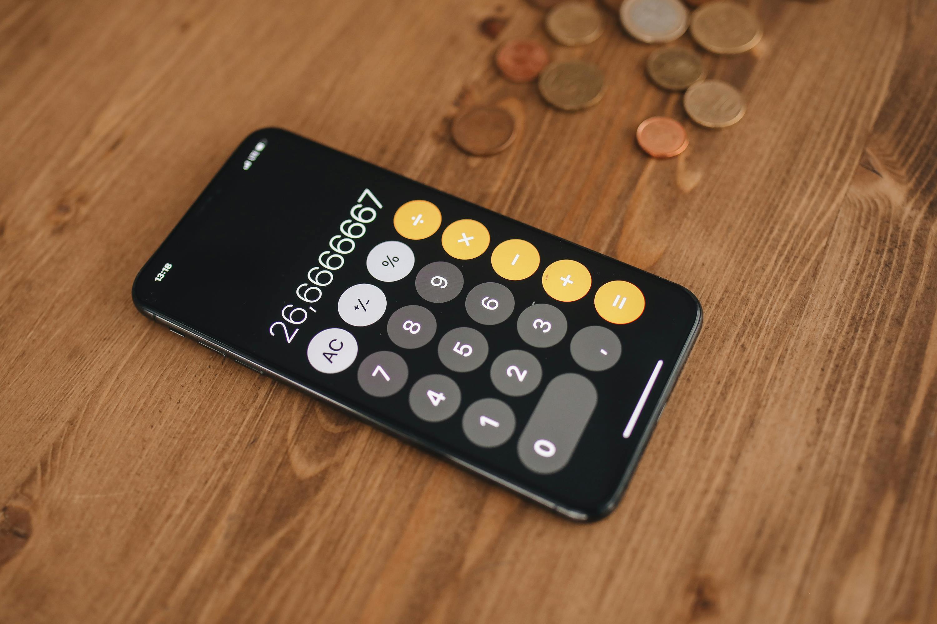 a mobile phone with calculator on a wooden table