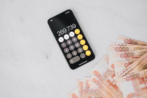 Free A Cellphone Calculator and Cash on a Flat Surface Stock Photo
