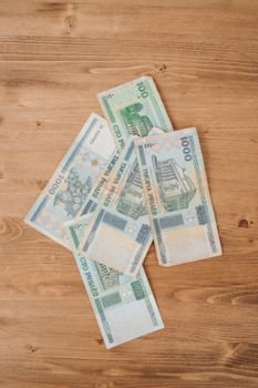 A flat lay of various Belarusian ruble banknotes on a wooden surface.