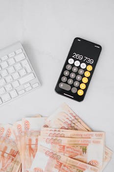 Image of a smartphone calculator and Russian rubles on a desk, related to finance and budgeting.