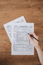 A Person Filling Out Taxation Documents on a Wooden Flat Surface