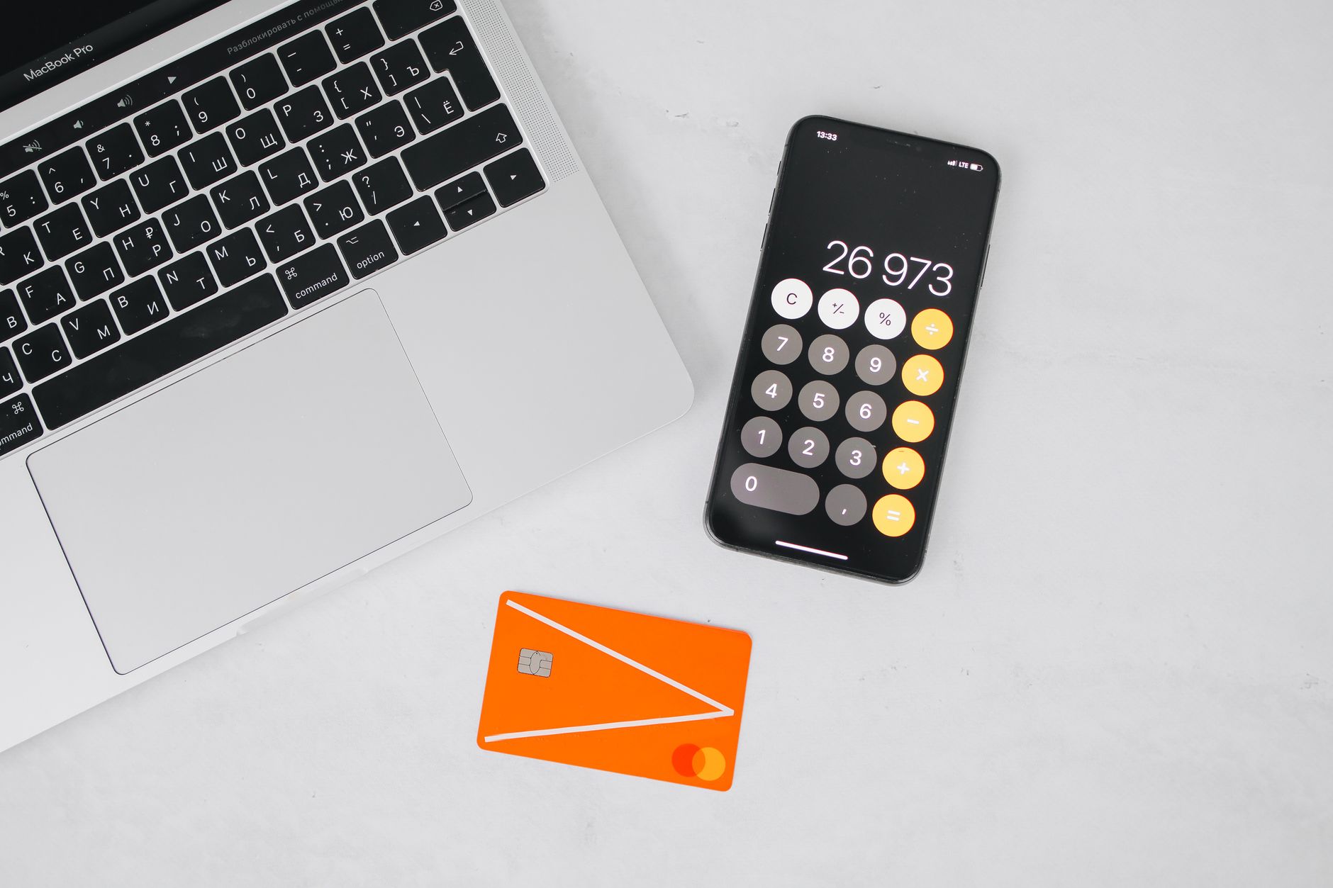Hand holding a credit card next to a calculator, suggesting budgeting and interest costs.
