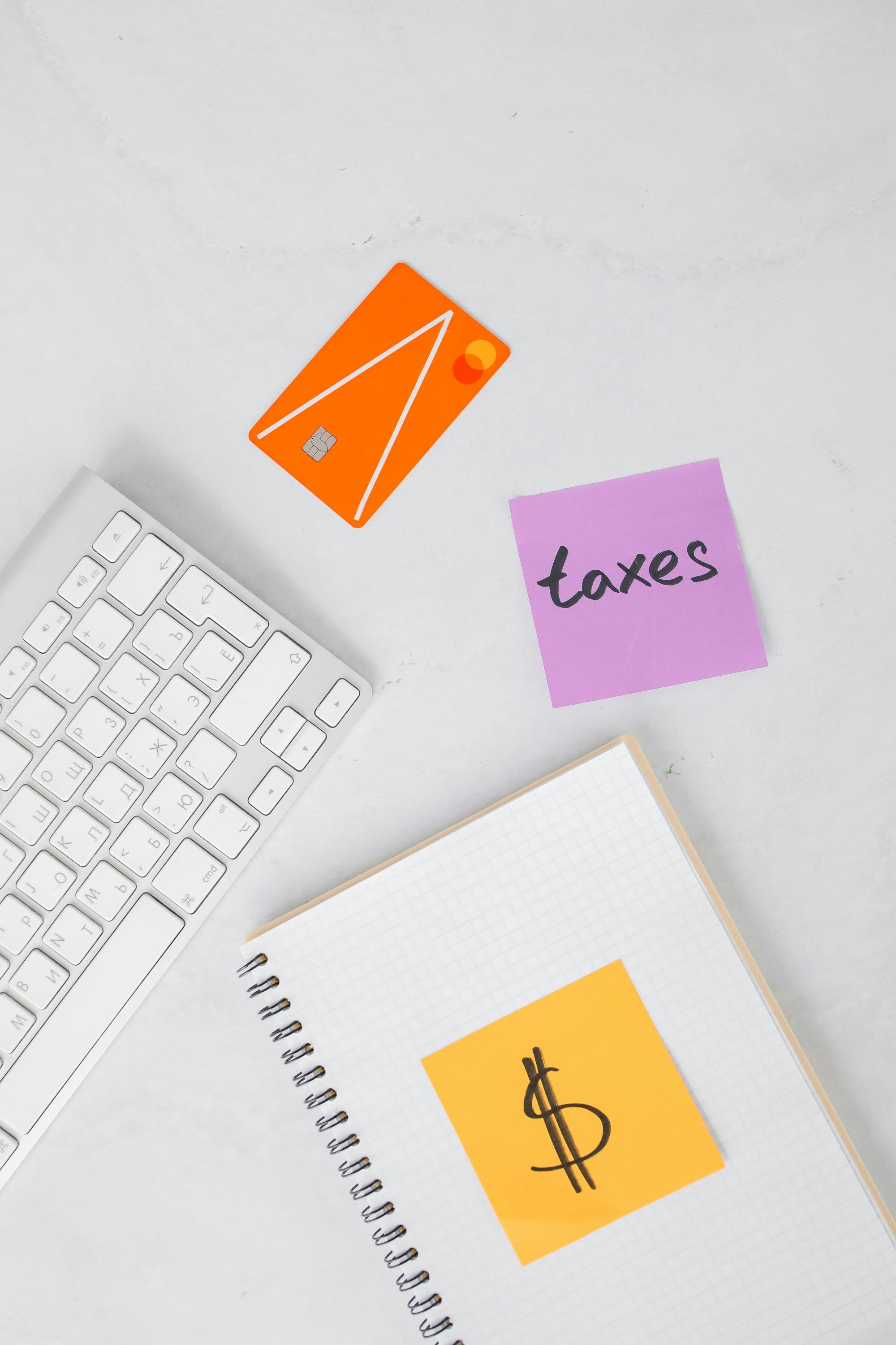 a notebook with sticky notes and credit card on a white surface