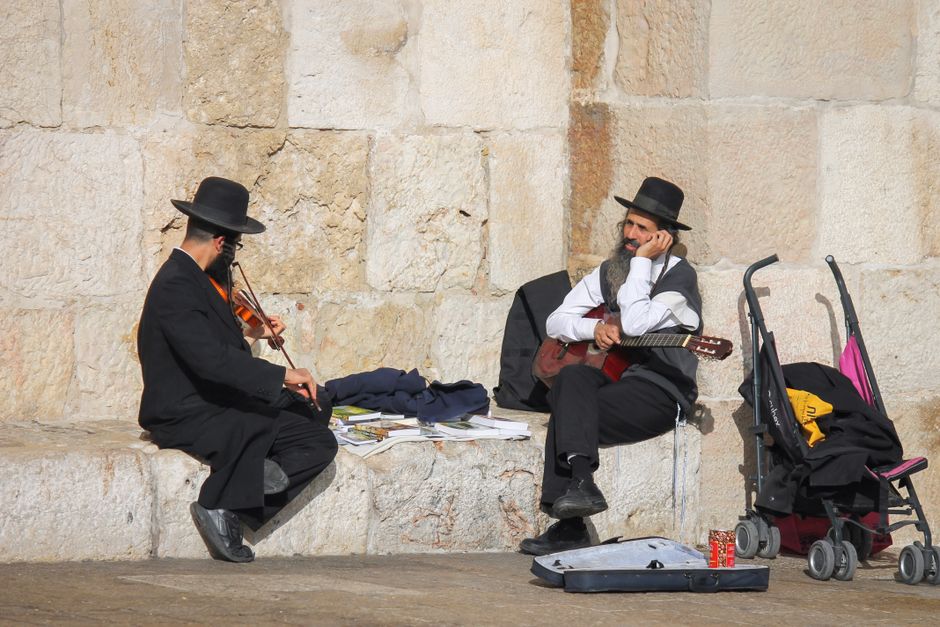 People observing traditions at the Western Wall in Jerusalem, Israel, dressed modestly