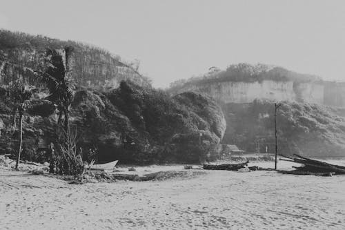 Sandy seashore surrounded by rocky cliffs in tropical resort