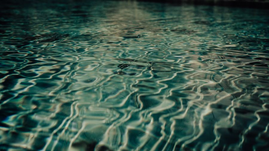 Rippled water surface catching low light. Photo by Zizi zi on Pexels.