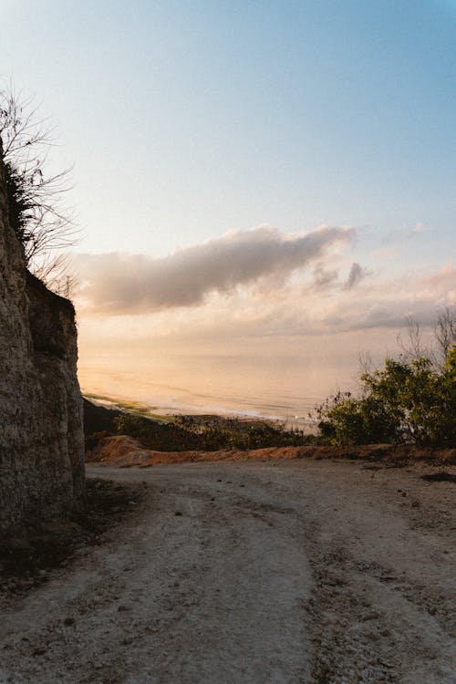 A Dirt Road Near the Rock Formation Under the Cloudy Sky