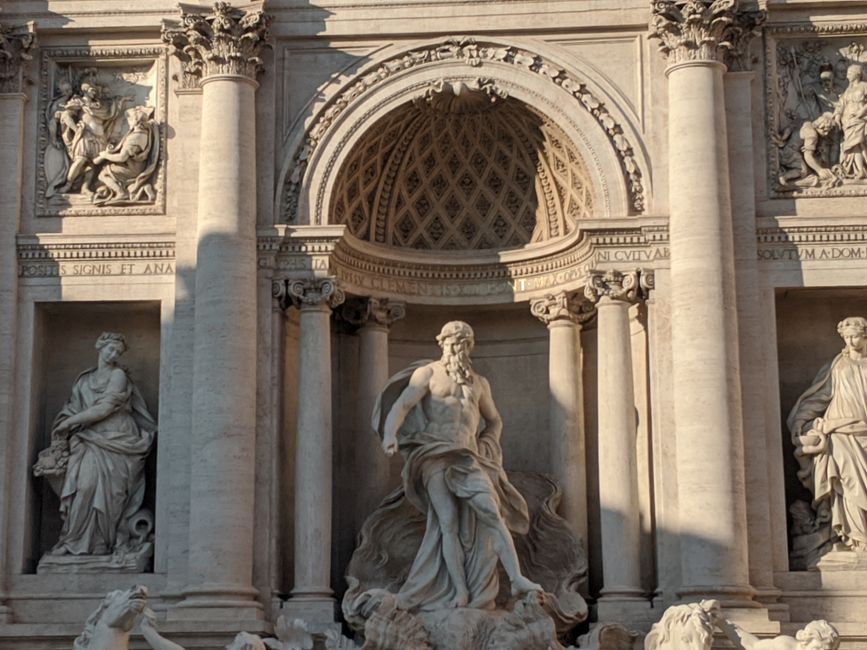 Close-up of the Trevi Fountain in Rome, showcasing its intricate baroque sculptures in sunlight.
