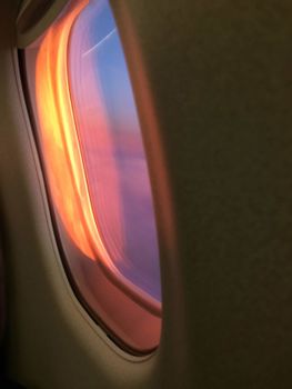 Stunning view of a vibrant sunset seen through an airplane window, capturing the colors of the sky.