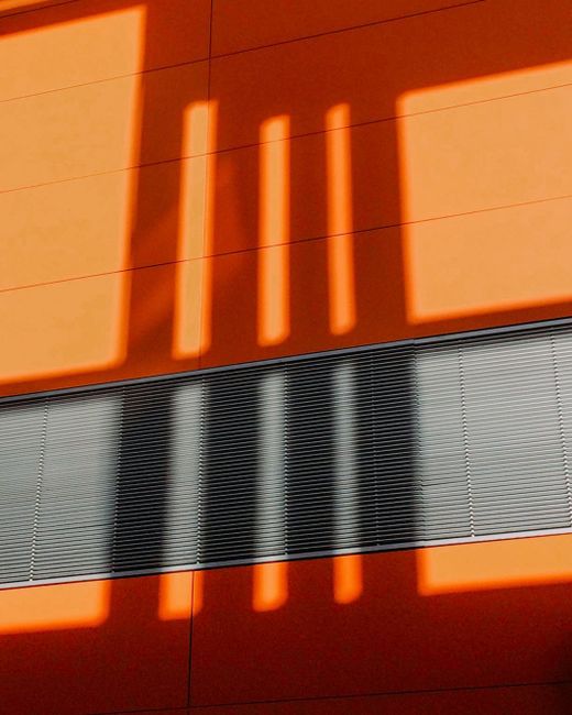 Colorful modern facade with geometric shadows and textures creating an artistic visual effect.