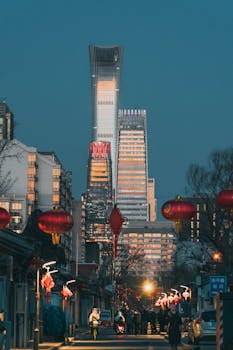 Beijing cityscape at night featuring traditional red lanterns and modern skyscrapers.