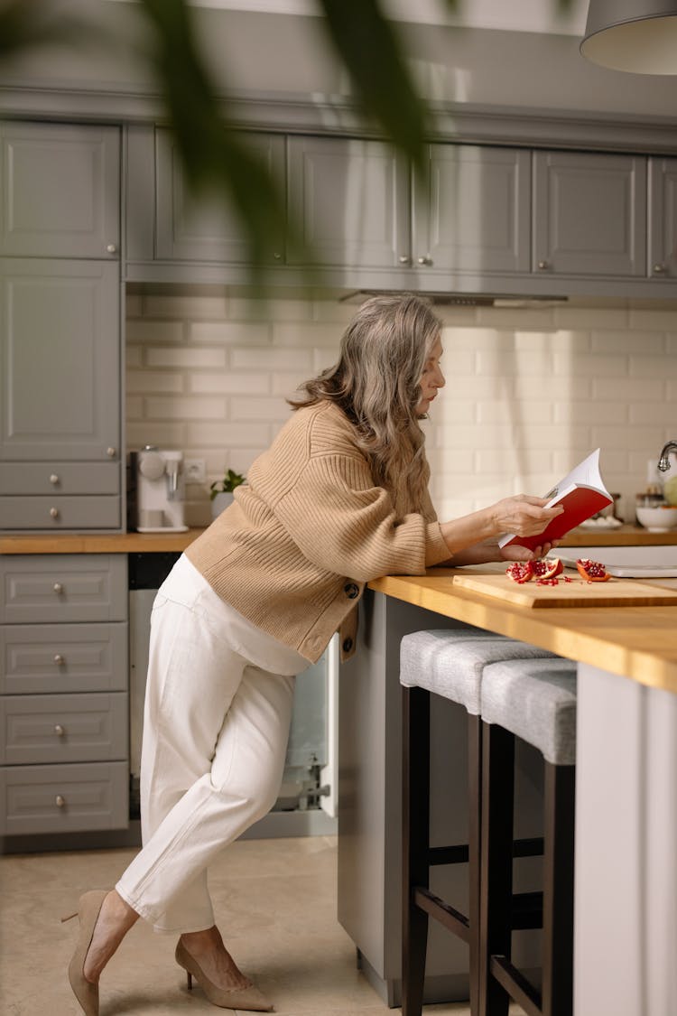 A Woman Reading A Book In The Kitchen