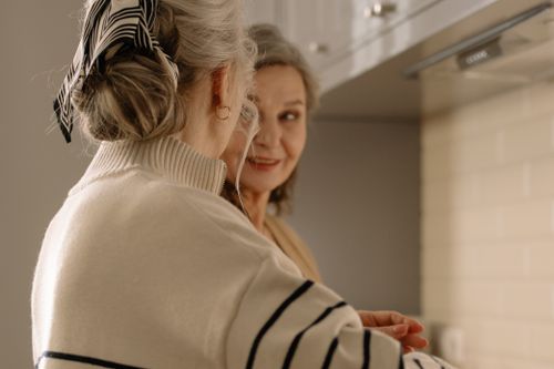 Free Two senior women having a joyful conversation in a cozy kitchen setting. Stock Photo