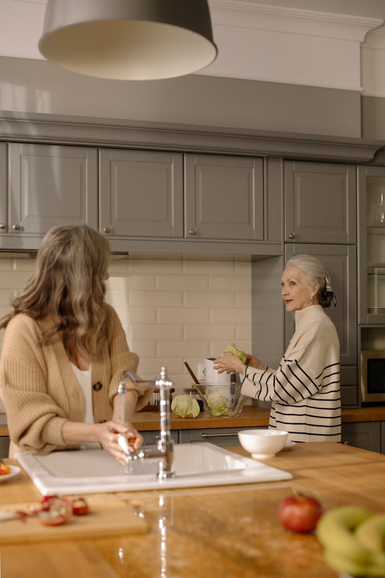 An Elderly Women Having Conversation In The Kitchen