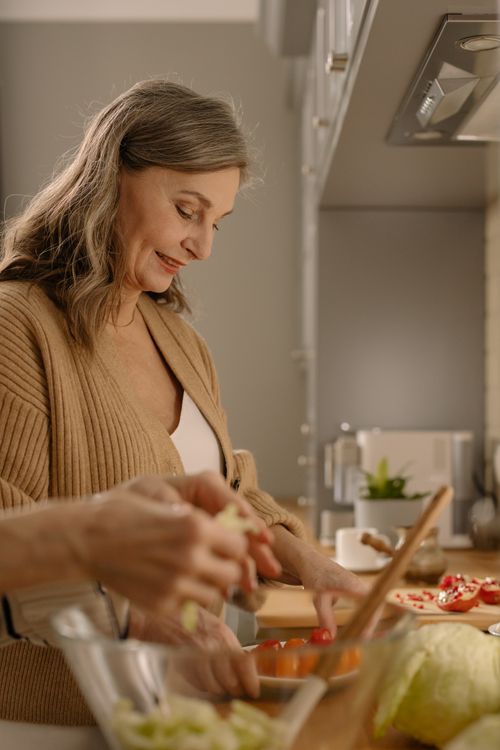 Free Elderly woman preparing a healthy meal in a bright, modern kitchen environment. Stock Photo