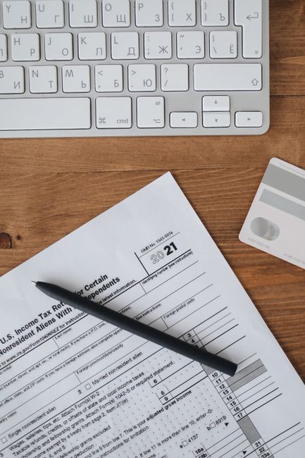 Photo by Polina Tankilevitch Top view of tax forms, keyboard, and credit card on wooden desk for business preparation.