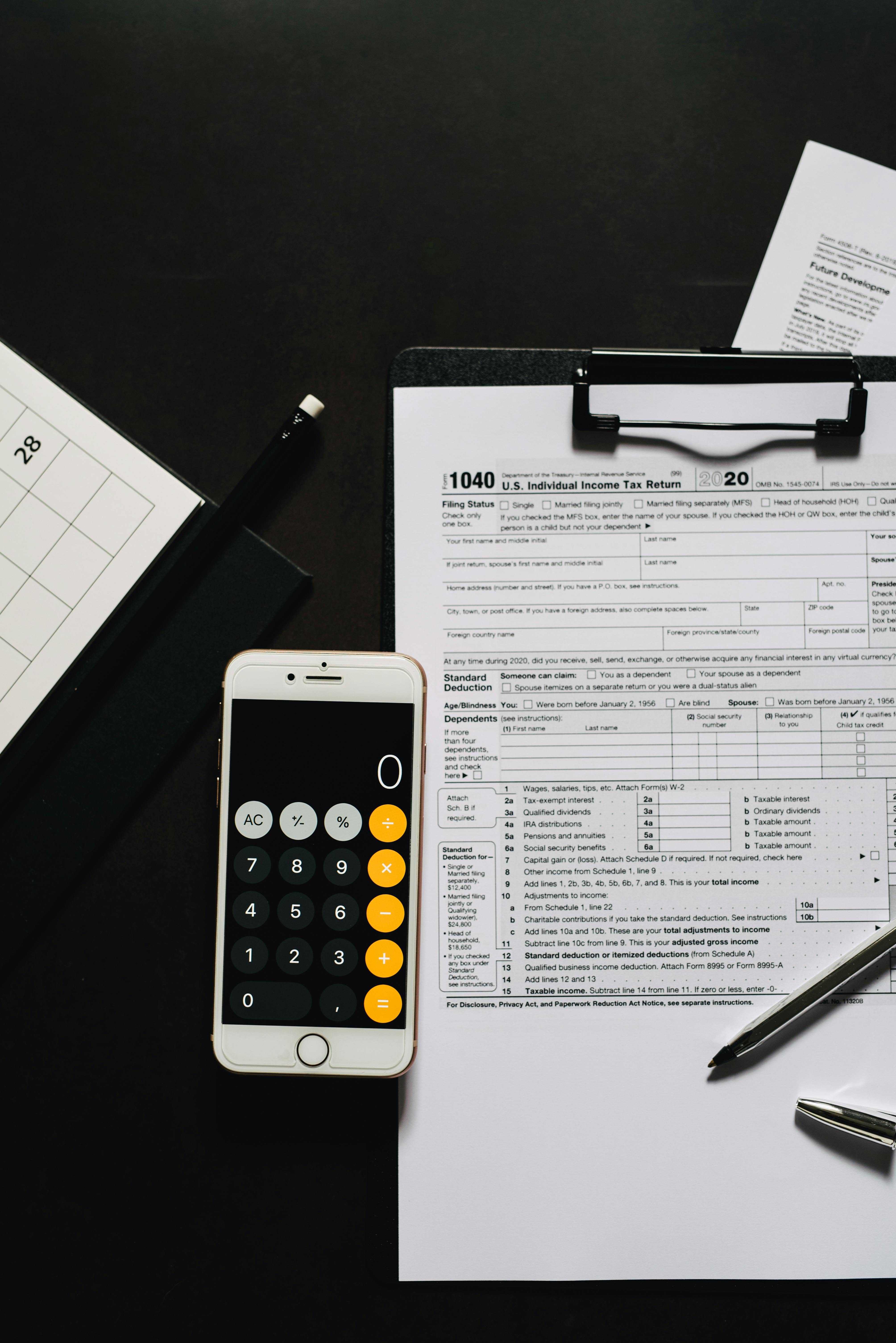 calculator smartphone on a clipboard with white paper