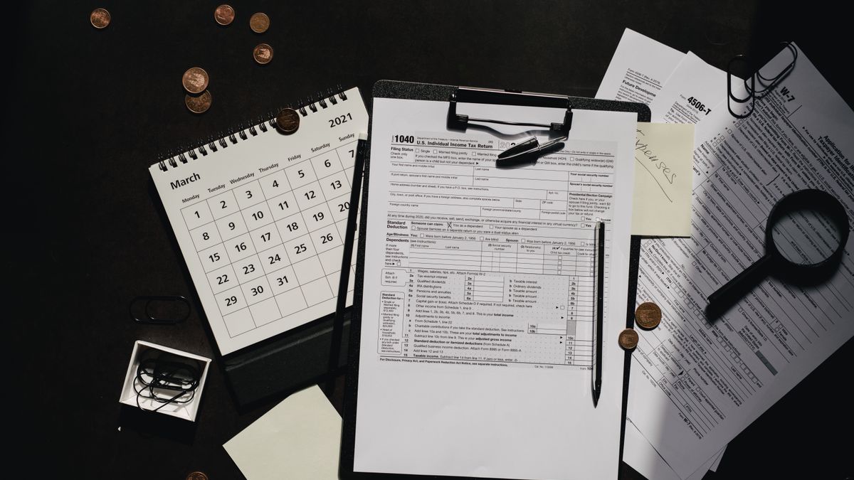 A neatly organized workspace featuring tax forms, calendar, magnifying glass, and office supplies for efficient tax preparation.
