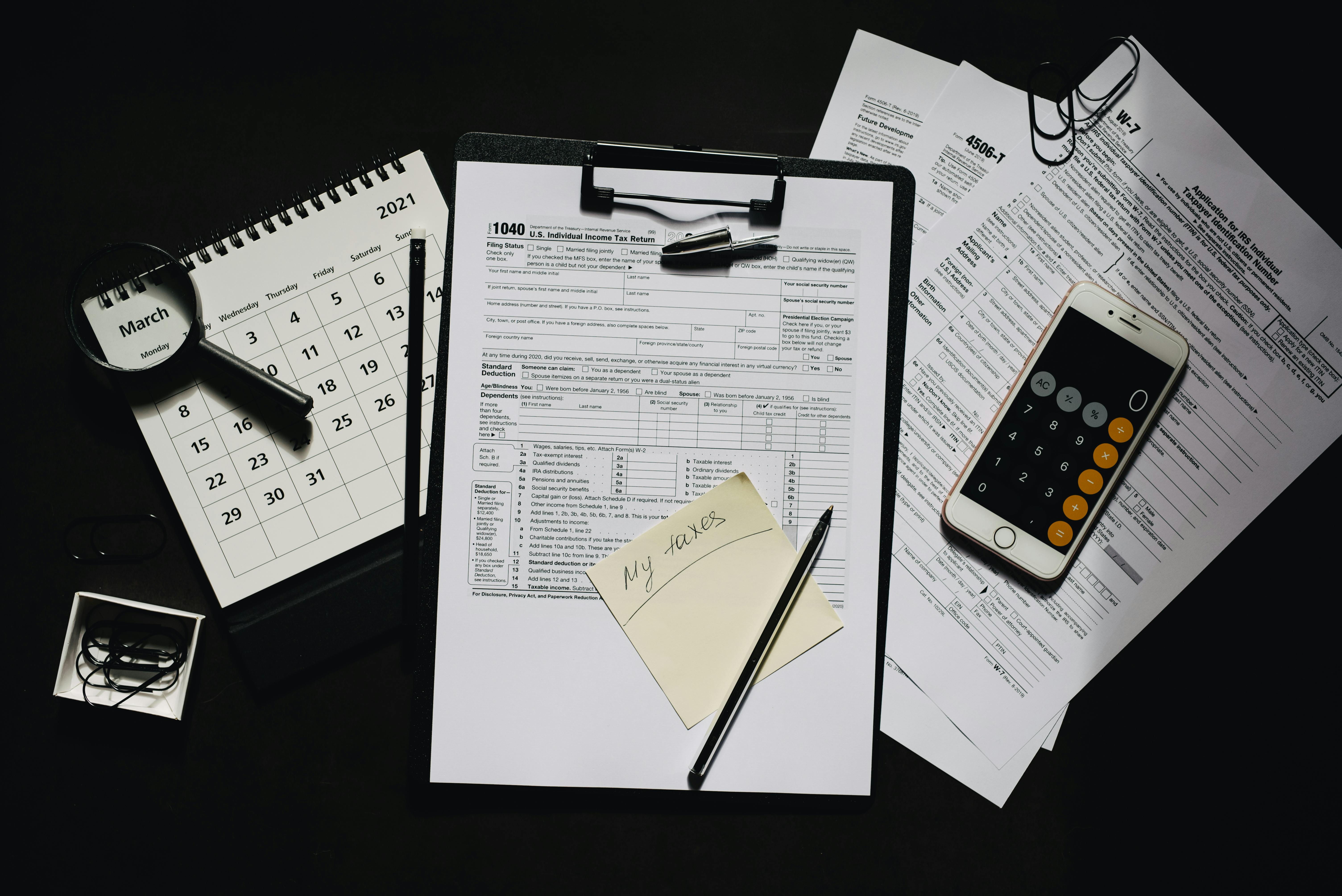 sticky note on a clipboard with a tax form