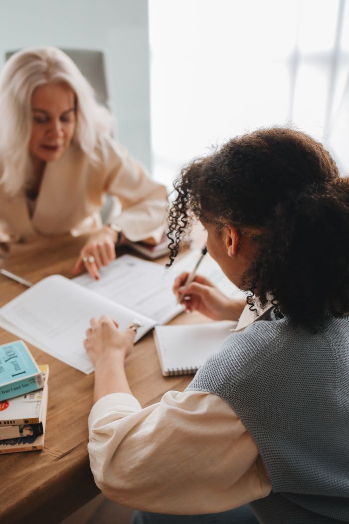 Discussing work at a table with notepads