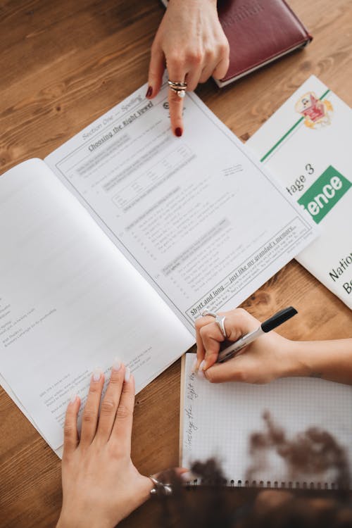 Free Person Writing Notes on Her Notebook Stock Photo