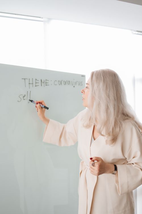 Free Adult woman teaching a coronavirus-related theme in an indoor classroom. Stock Photo