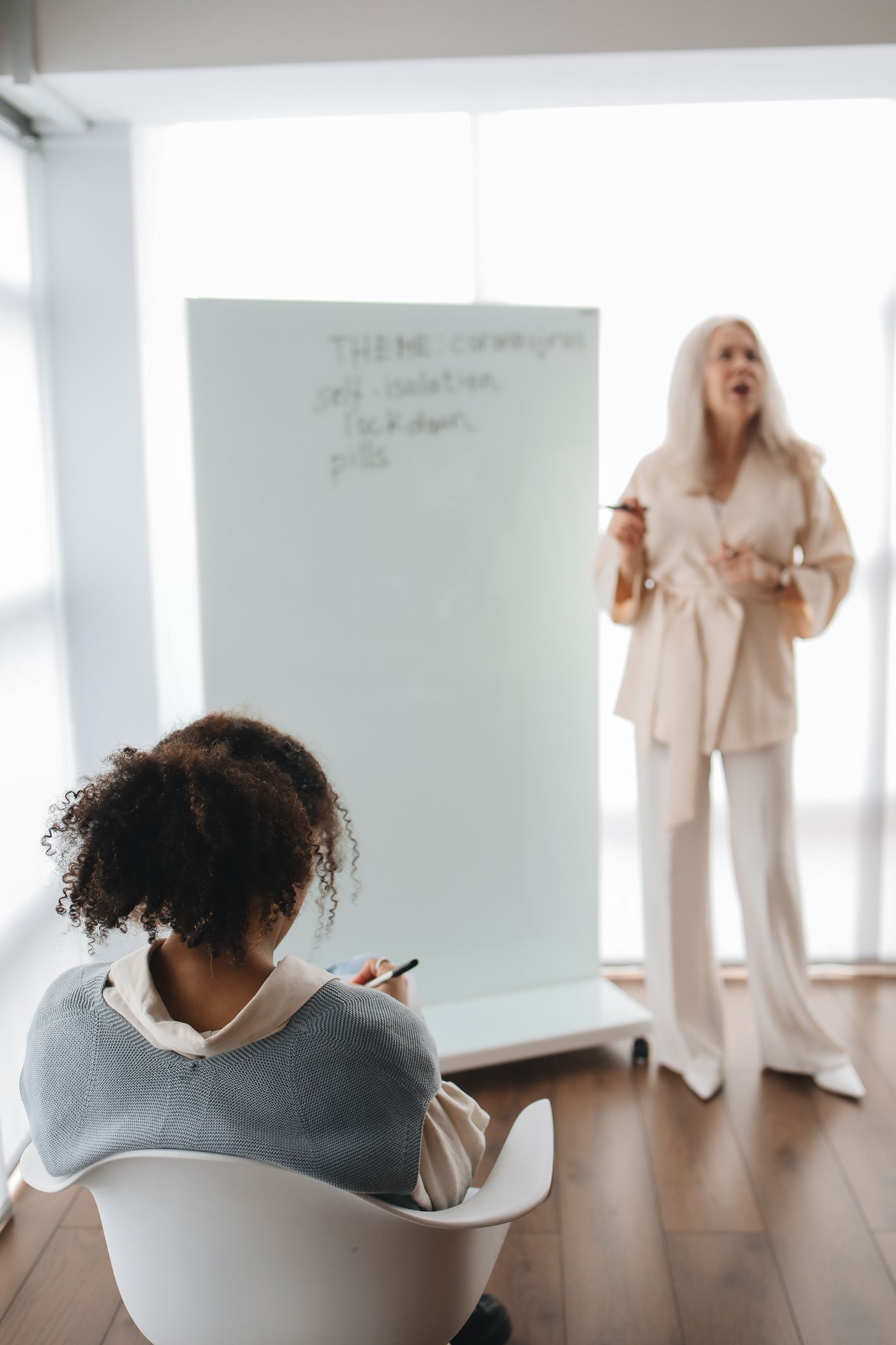 Une formatrice échange avec une apprenante dans une salle de classe