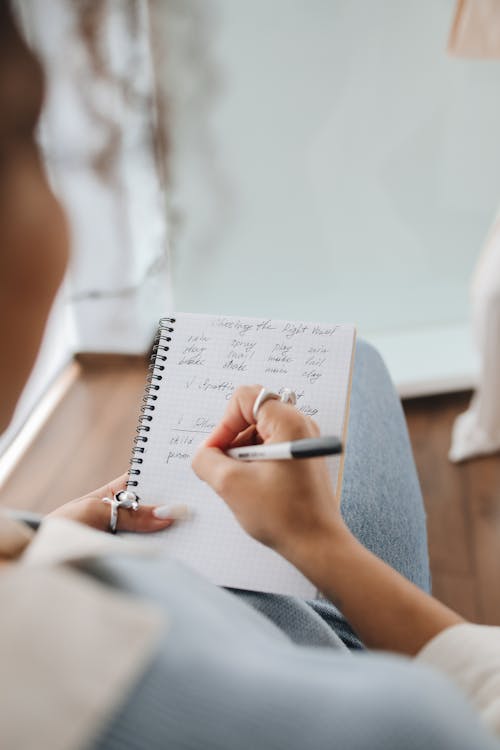 Free Student Writing Notes on Her Notebook Stock Photo