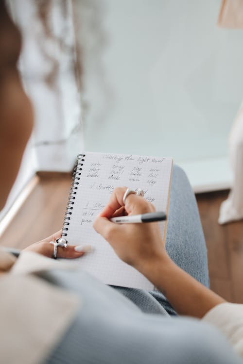 Student Writing Notes on Her Notebook