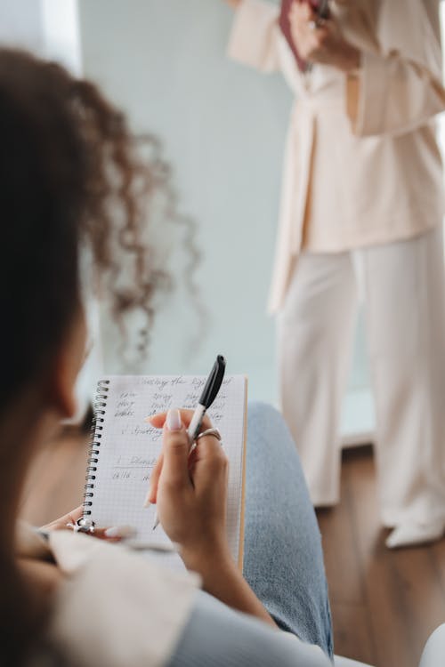 Free Student Writing Notes on Her Notebook Stock Photo