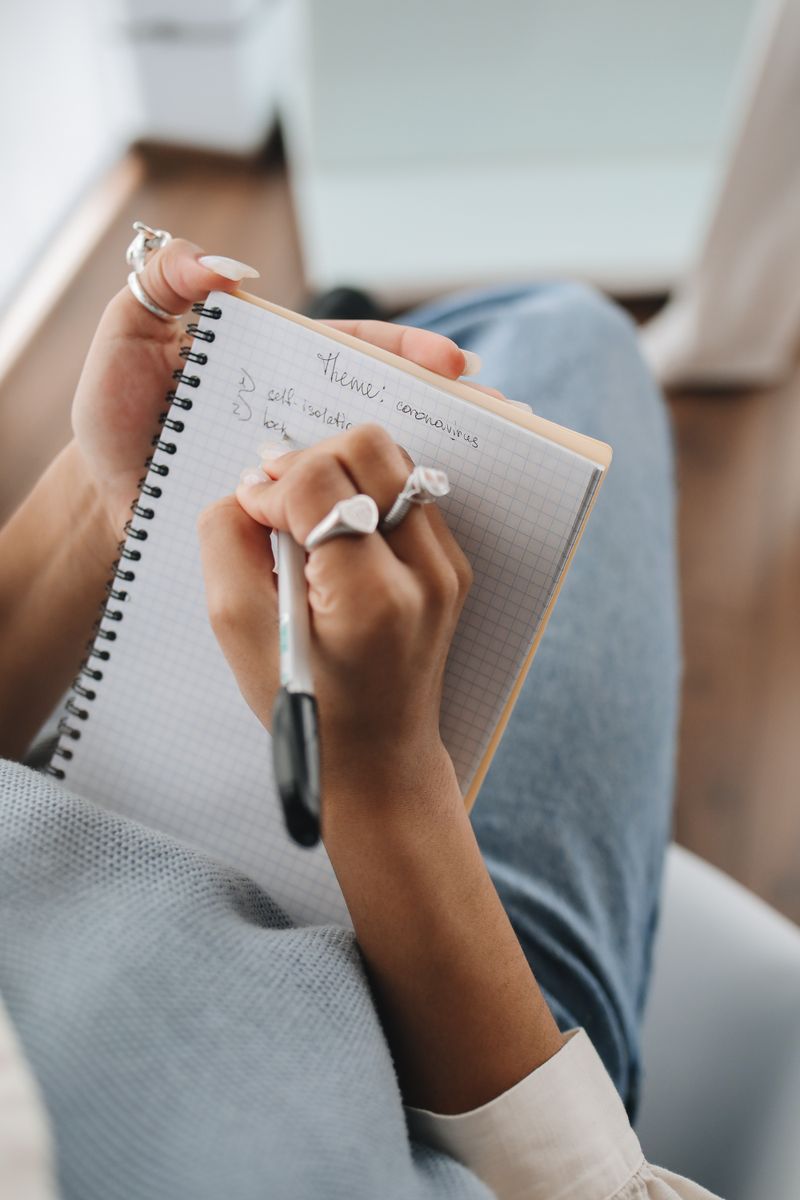 Close-up of handwritten notes being recorded in a lined spiral notebook