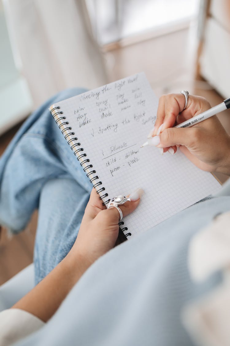 Student Writing Notes On Her Notebook