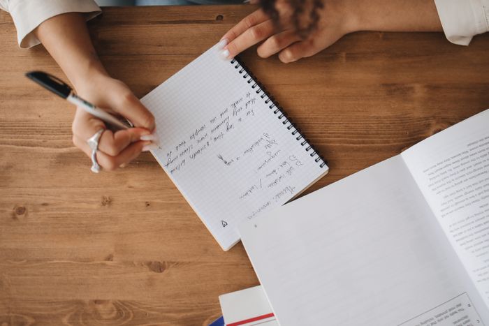 Researcher writing session notes in a grid notebook — photo by Polina Tankilevitch on Pexels