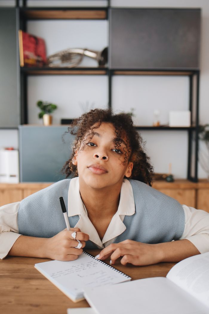 Student doing handwritten homework and note taking at a desk