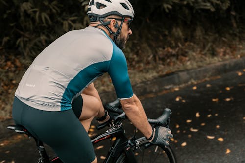 Free Man in Sportswear and Helmet Riding a Bicycle Stock Photo