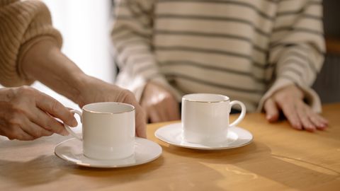 Cozy morning scene with two cups of coffee on a wooden table, captured intimately indoors.