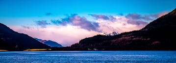 苏格兰高地景色宜人，宁静的海水、雄伟的山脉与黎明时充满活力的天空相映成趣