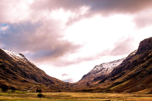 Free Breathtaking view of Glencoe Valley with snow-capped mountains and a dramatic sky. Stock Photo