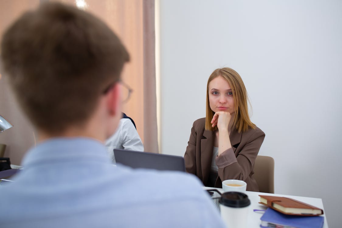 Free Woman in Brown Long Sleeve Shirt Sitting Beside Woman in Blue Sweater Stock Photo