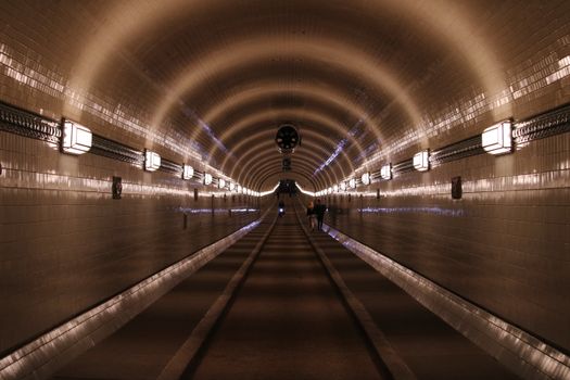 A mesmerizing view inside the iconic Elbe Tunnel in Hamburg, Germany, with people walking through.