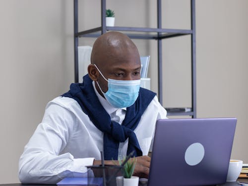 A Man in White Long Sleeves Using a Laptop