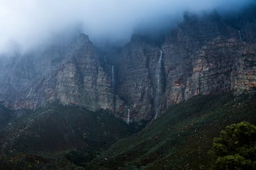 Dark Photo of Rocks in Mist with Tiny Waterfalls