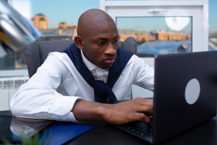 A Man In White Long Sleeves Using Laptop