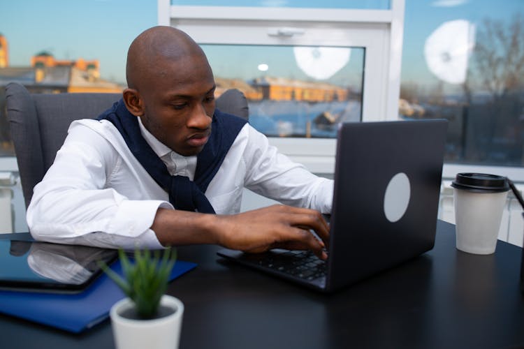 A Man Using A Black Laptop