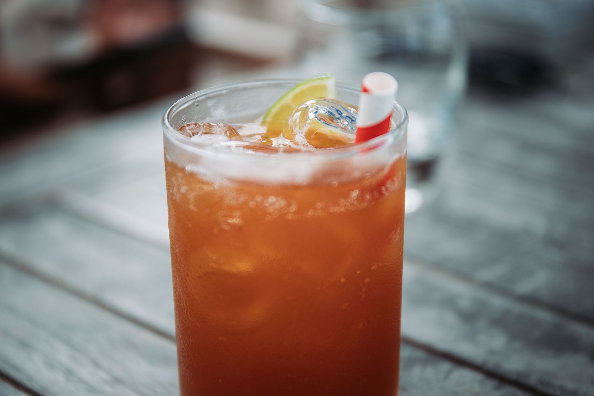 A refreshing citrus cocktail served with ice and a lime slice, perfect for outdoor enjoyment.
